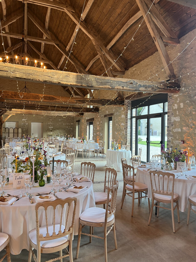 salle de mariage en pierre avec chaises blanches