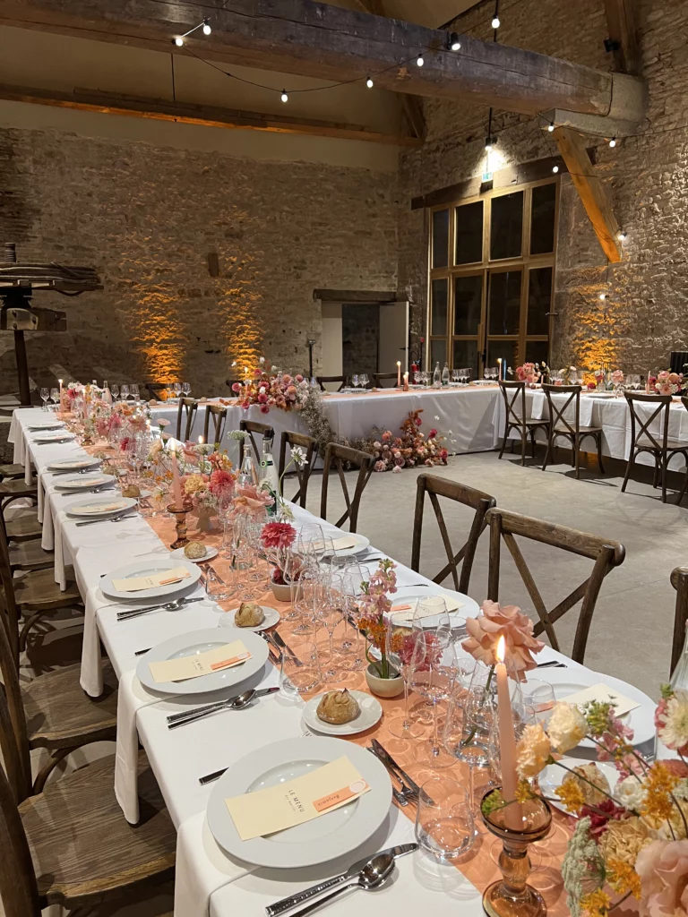 décoration d'une salle de mariage par Caro&Co Wedding Planner Dijon dans les tons orangés avec beaucoup de fleurs