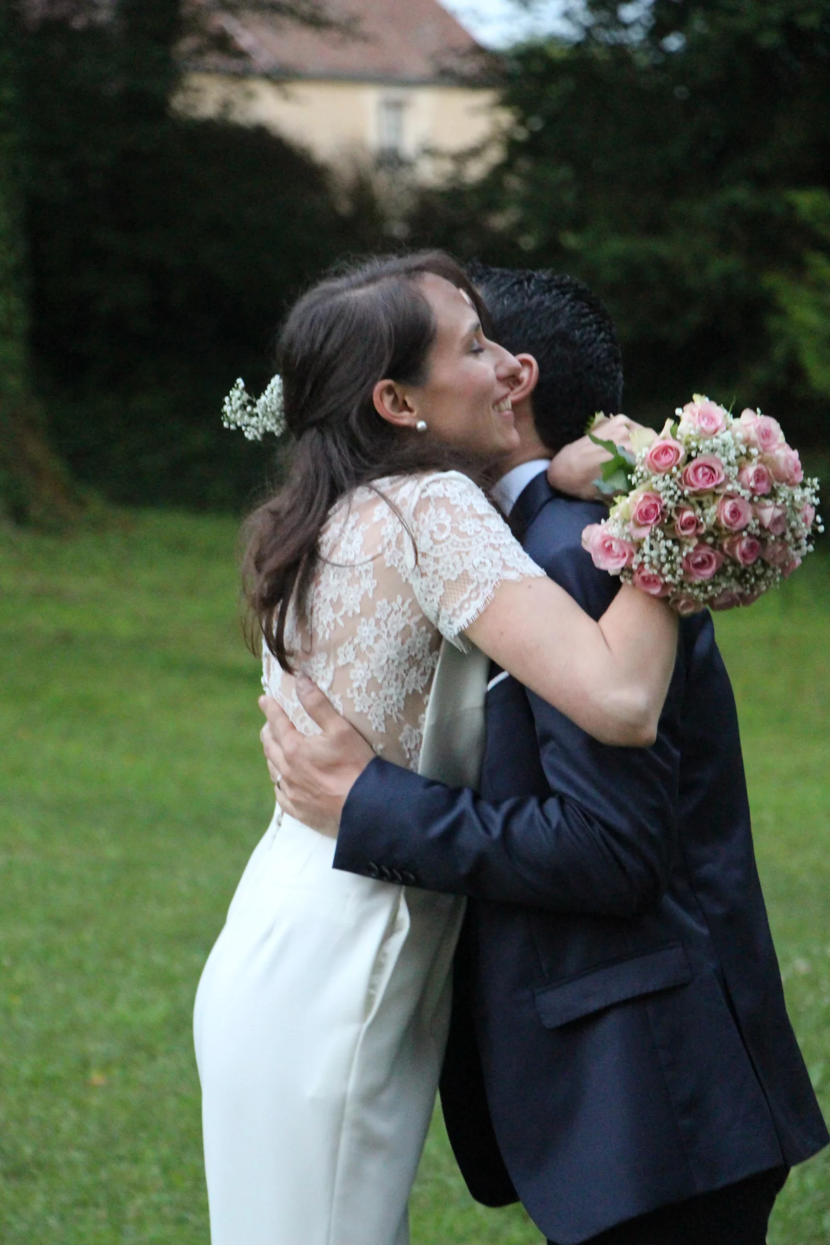 mariés qui s'enlacent avec un bouquet de rose et gypsophile